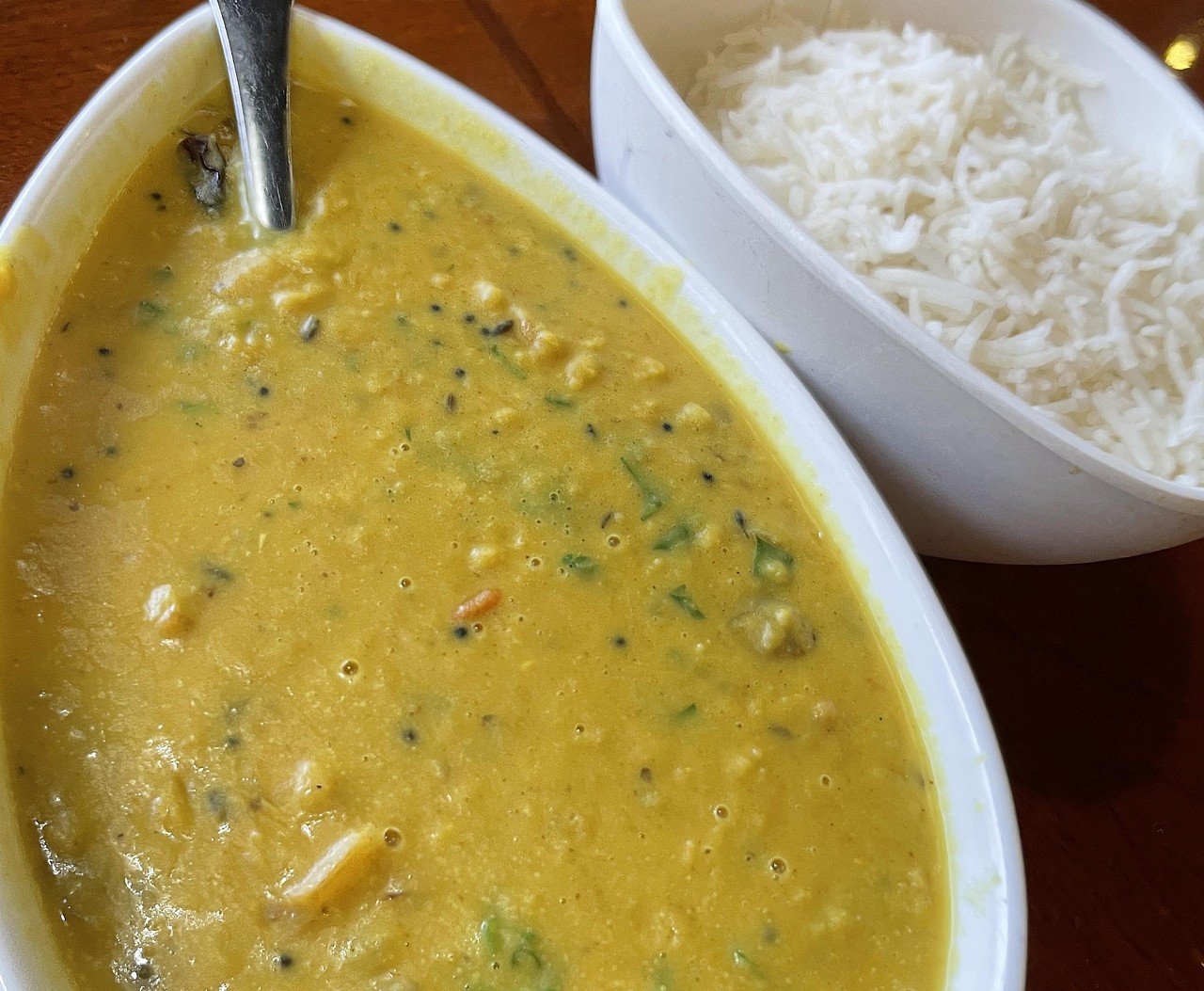 Hyderabad House Louisville
12412 Shelbyville Rd.
Think Indian, think of curry, and also of dal, a comforting, spicy lentil stew. Creamy coconut daal curry at Hyderabad House combines both! It consisted of tender yellow lentils bathed in a simmering bright-yellow curry-scented soup studded with a few bright cubes of tomato. Its mild lentil flavor blended with coconut and turmeric scents with haunting back notes of mysterious, delicious Indian flavors. Ordered mild, it presented a gentle heat imparted by a single small charred chile pepper.