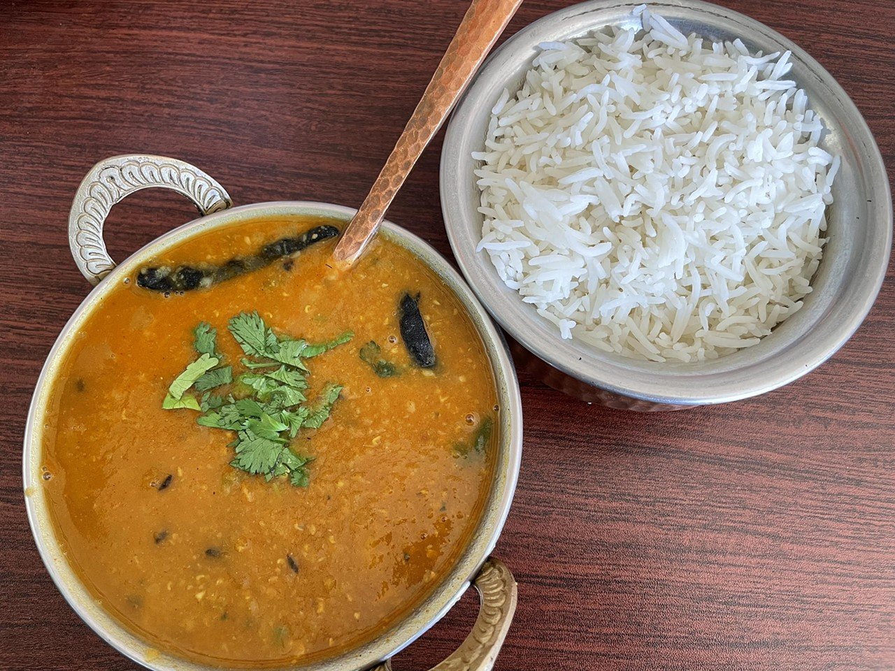 Kathmandu Kitchen
3825 Bardstown Rd.
Kathmandu Kitchen is Nepalese, but I’ll call that Indian-adjacent because it’s right next door to India, and its cuisine shares a delicious kinship.  I recommend daal jhanneko, a Nepalese cousin of the Northern Indian lentil dish dal tadka. This thick, savory lentil soup comes with yellow or black lentils simmered to a thick, savory porridge, then kicked up with a complex, piquant tadka spice mix of cumin seeds, onion, tomato, cilantro, ginger, and garlic … plus three tiny but dangerous looking chile peppers to create that desirable hot-stuff endorphin rush.