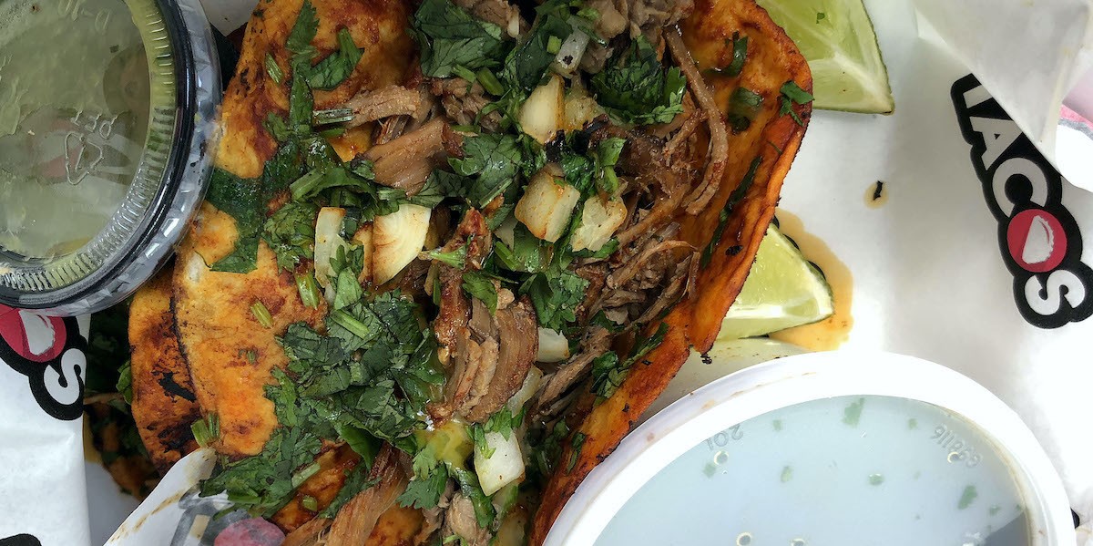 I Love Tacos' birria tacos, a tradition from Guadalajara in Mexico's Jalisco province, feature long-simmered, tender brisket on flour tortillas grilled in a spicy adobo sauce, served in traditional style with cilantro and onion.  |  Photo by Robin Garr.